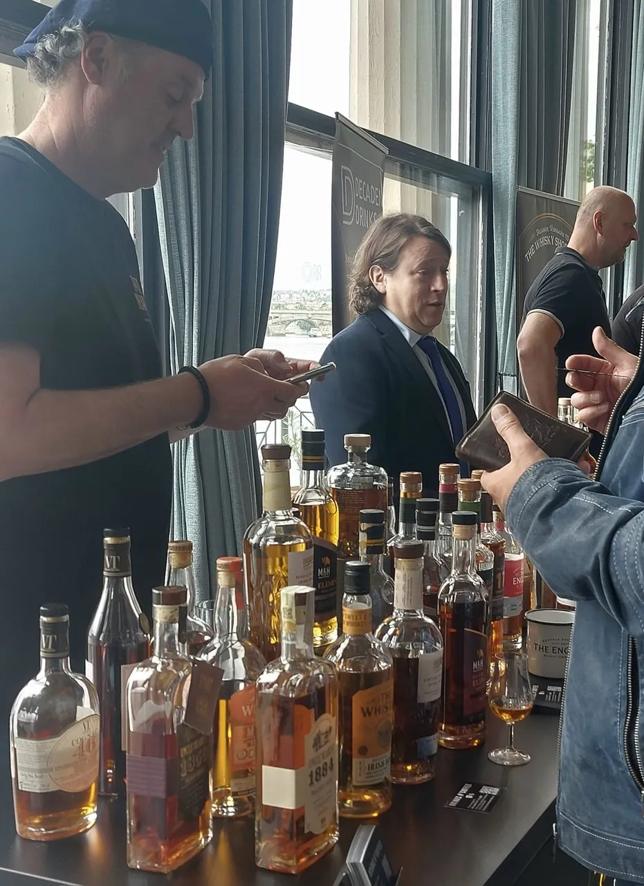 Stůl s lahvemi u stánku Decadent Drinks a The Whisky Shop